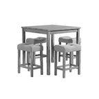 gray counter height dining table set with four upholstered fabric chairs shown from front angle in dining space